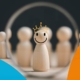 In herausfordernden Zeiten die Hoffnung und Zuversicht bewahren (Symbolbild: lächelnde Spielfigur als positiver Leader)